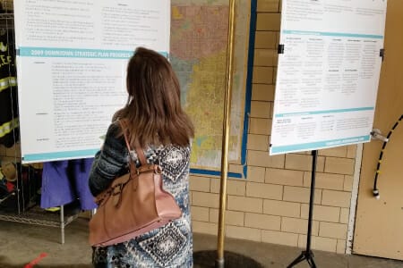 Woman looking at info board at community event