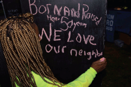 "Born and rasied here; 50 years; we love our neighbors" written on a chalkboard in pink writing